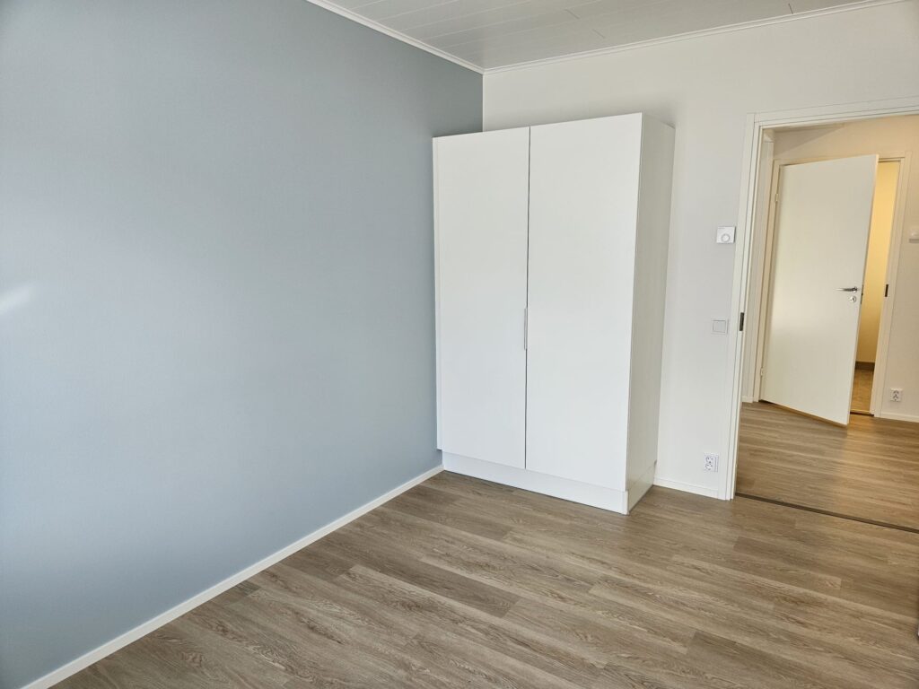 Makuuhuone sinisävyisellä seinällä