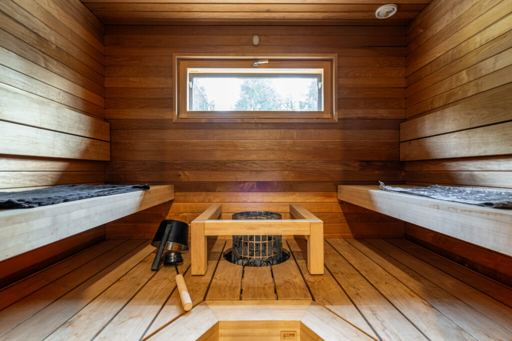 sauna vastakkain istuttavilla lauteilla. kiuas on lauteiden välissä